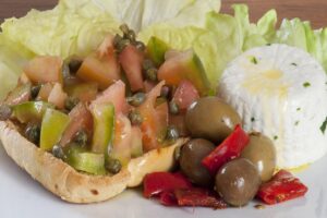 Caponata siciliana con melanzane, pomodori e olive, servita in un piatto tradizionale.