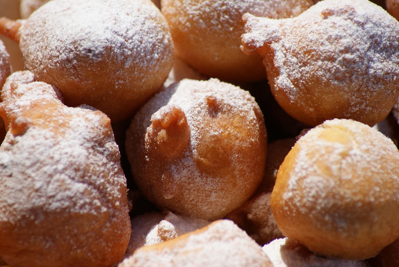 Frittelle veneziane dorate e spolverate di zucchero, servite su un piatto elegante.