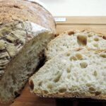 Pane casereccio a lievitazione naturale appena sfornato, crosta dorata e alveolatura perfetta.