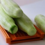 Zucchine trombetta grattugiate su un tagliere, pronte per una ricetta estiva salutare.