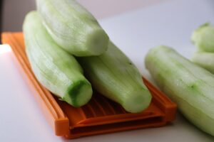 Zucchine trombetta grattugiate su un tagliere, pronte per una ricetta estiva salutare.