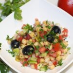 Insalata di ceci e menta fresca, servita in un piatto colorato, ideale per un pranzo estivo leggero.