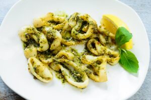 Calamari croccanti in padella, piatto appetitoso senza frittura, pronto da gustare.