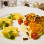 Polenta cremosa servita in un piatto, con burro fuso e formaggio, simbolo della cucina regionale.