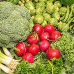 Verdure fresche di stagione per ridurre il colesterolo alto, su un piatto colorato per il pranzo.